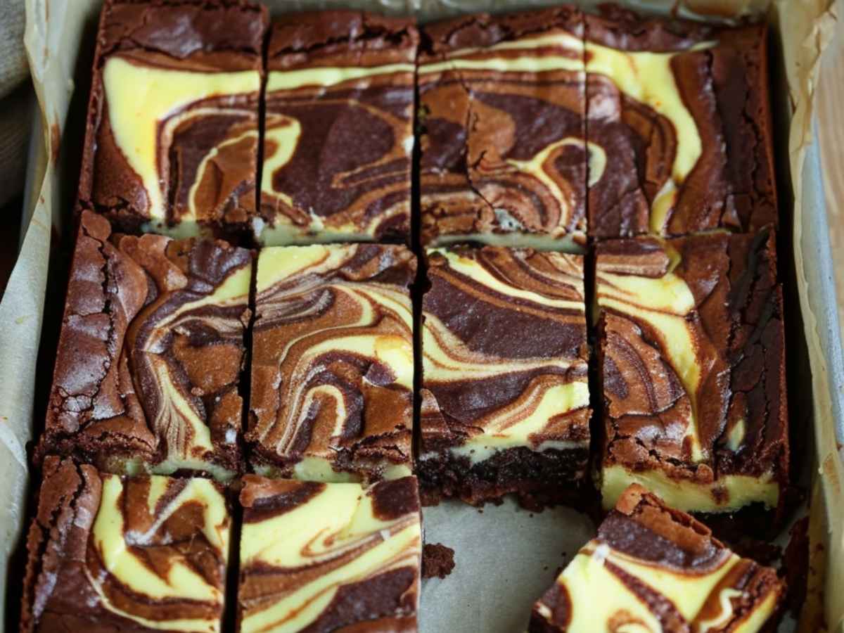 Sernikobrownie – przepis na wilgotne brownie z warstwą sernikową 1 Sernikobrownie – wilgotne brownie z warstwą sernikową i marmurkowym wierzchem, pokrojone na kawałki